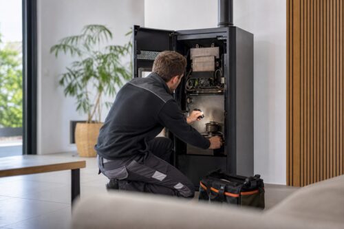 Technicien contrôlant un poêle à granulés ouvert après un code erreur