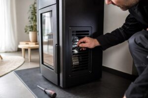 Technicien inspectant la grille de ventilation d’un poêle à granulés