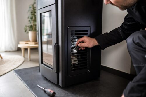 Technicien inspectant la grille de ventilation d’un poêle à granulés